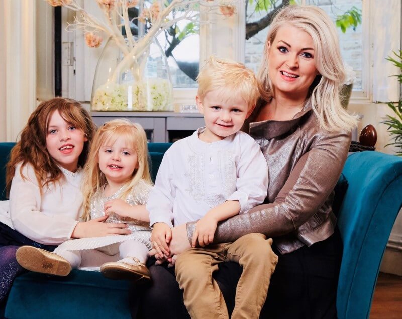 Kate Hardcastle on a sofa with her three children