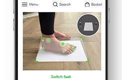 Image of SizeWise scan in progress with child's foot on A4 paper.