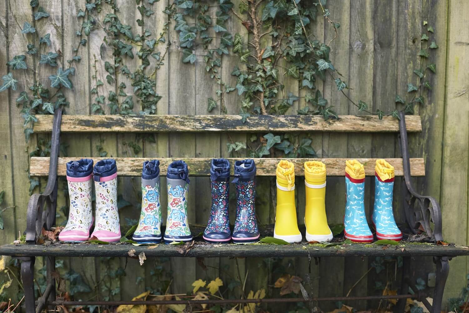 Pairs of children's wellies on a bench outside