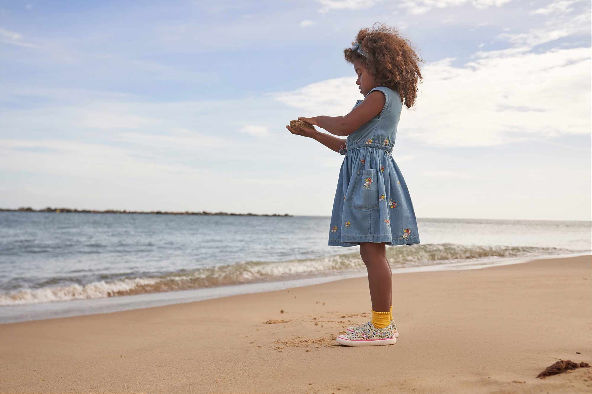 Girl wearing canvas shoes on beach