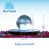 Dimensions - Acrylic Crystal Sphere fountain on a pedestal surrounded by vibrant red flowers. Text reads "Blue Thumb" with installation dimensions and "Easy to Install."
