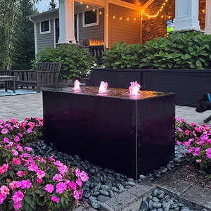 Triple Cuboid Fountain by night lit with pink plumes