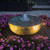 Brass Patina Reflection Bowl Fountain Kit at night, lit with lighting kit