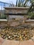 Blue Thumb Large Formal Falls waterfall installed in a natural stone retaining wall with a wide cascading sheet of water flowing onto decorative river rock.