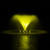 A yellow-lit fountain sprays water upwards in a symmetrical pattern against a dark night backdrop, creating a serene and glowing reflection on the water surface.