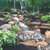 Installed pond-less waterfall cascading  down rocks with  beautiful garden foliage