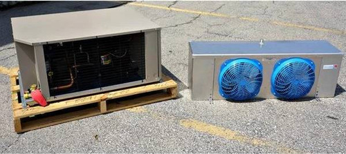Beige condensing unit on a wooden pallet alongside a dual-fan evaporator unit