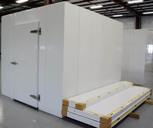 White walk-in cooler unit with closed hinged door and insulated panel walls, including ceiling panels alongside