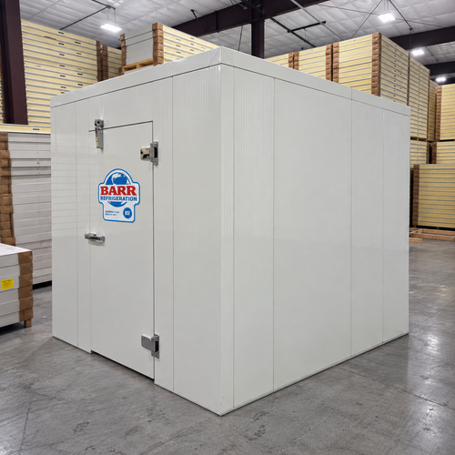 White walk-in cooler unit with closed hinged door and insulated panel walls front left view