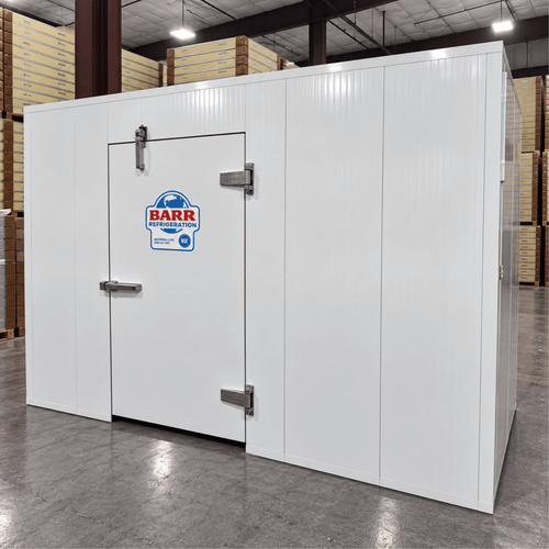 White walk-in cooler unit with open door showing interior, featuring insulated panel walls front with door closed