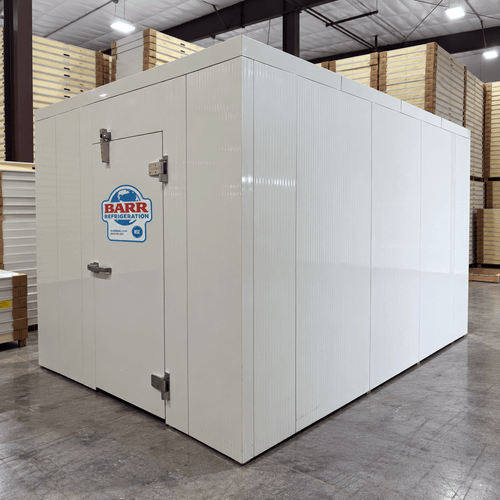 White walk-in cooler unit with closed hinged door, featuring insulated panel walls front right view