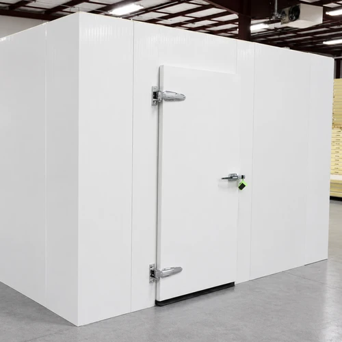 White walk-in cooler unit with closed hinged door, featuring insulated panel walls front side view