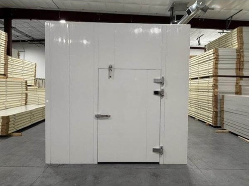 White walk-in cooler unit with closed hinged door, featuring insulated panel walls