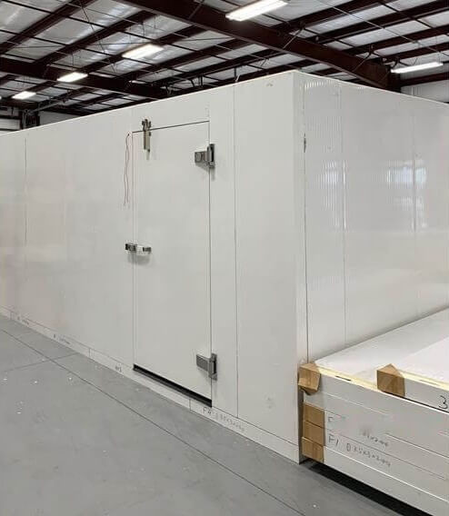 White walk-in commercial freezer with ceiling panels next to it