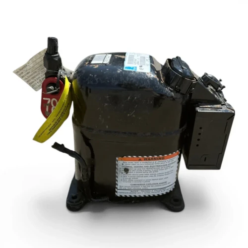 Front-left view of a used Copeland AJB7465AXD .75 HP compressor (1 phase 208-230 volt), a black reciprocating compressor with rust spotting on the shell, a red inventory tag "782," and a paper service tag with a handwritten checklist ("OIL SCREEN, OHM, MEGOHM, OIL CHANGED, ROD CHECKED").
