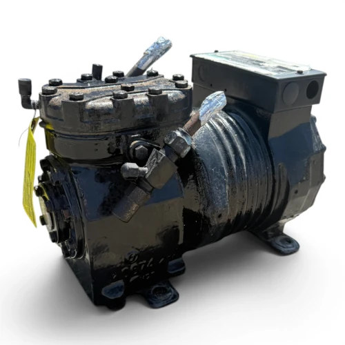 Right-side view of the used Copeland KAKA-010A-TAC 1 HP compressor, showing the terminal box, an orange/yellow "DANGER" warning label, and the finned motor housing with visible surface rust spots.