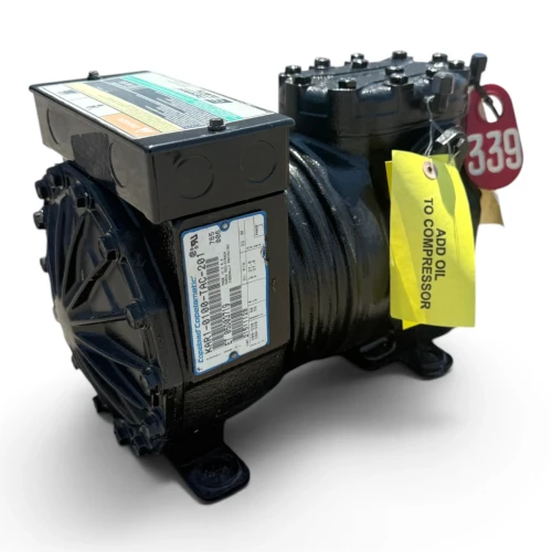 Left-side view of the used Copeland KAR1-0100-TAC 1 HP compressor, showing the bolted cylinder head, terminal box, and a stamped number on the base casting, with no tags visible on this side.