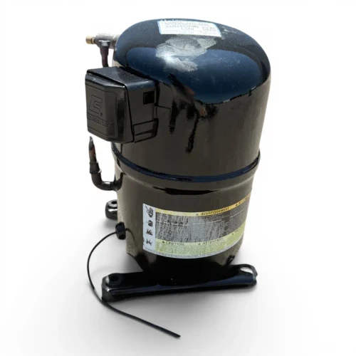 Front-left view of a used Copeland CF04K6E-TF5 1 HP compressor (3 phase 208-230 volt), a black hermetic scroll-style compressor with white paint markings ("CSW" and additional text) on the dome, a black Copeland terminal box on the left, and a bilingual "AVERTISSEMENT/ADVERTENCIA/CAUTION/ATTENTION" warning label on the shell.