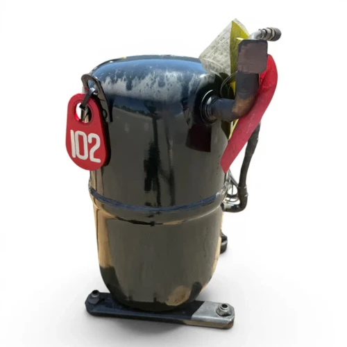 Front view of the same used Copeland CR30K6E-PFV 2.5 HP compressor, 1 phase 208-230 volt, showing the copper valve stub at the top right, a yellow warning label on the lower left, and the red "102" tag visible near the top.