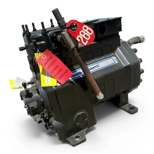 Front-left 3/4 view of the used Copeland 2DL3-F20KL-TFC 4 HP Discus compressor (3 phase, 208-230 volt), again showing the red round "288" tag and nitrogen-charge caution tag, with a foil-capped copper elbow fitting visible at the right side.