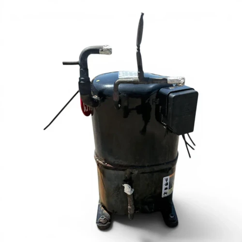 Front-left view of the used Copeland CRM3-0400-PFV 4 HP compressor (1 phase, 208-230 volt), a black cylindrical tank-style unit with two bent copper process stubs at the top (one foil-capped), a dark terminal box with hanging black wires on the right, a rusty weld seam around the mid-body, and a gray tripod base.