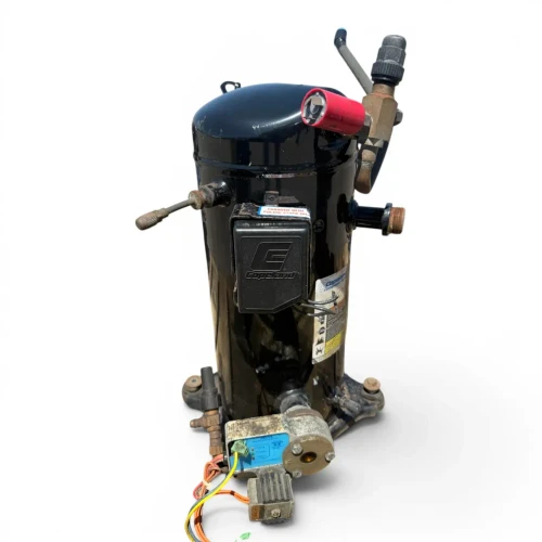 Front view of the used Copeland ZF13K4E-TFD 4 HP scroll compressor (3 phase, 460 volt) showing the Copeland-branded terminal cover, a "CHARGED WITH POLYOL ESTER OIL" sticker, the red-capped valve and blue-capped fitting at top, and a blue oil-level control module with wiring mounted at the base.