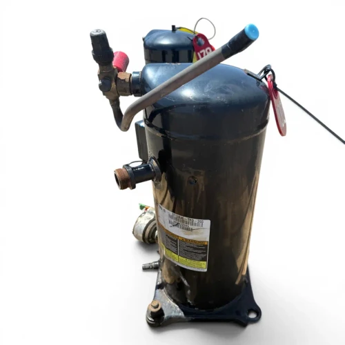 Front view of the used Copeland ZF13K4E-TFD 4 HP scroll compressor (3 phase, 460 volt), showing the nameplate reading "ZF13K4E-TFD-265" with a multilingual WARNUNG safety sticker, a red-capped ball valve and blue-capped fitting at the top, and a red round inventory tag partially visible.