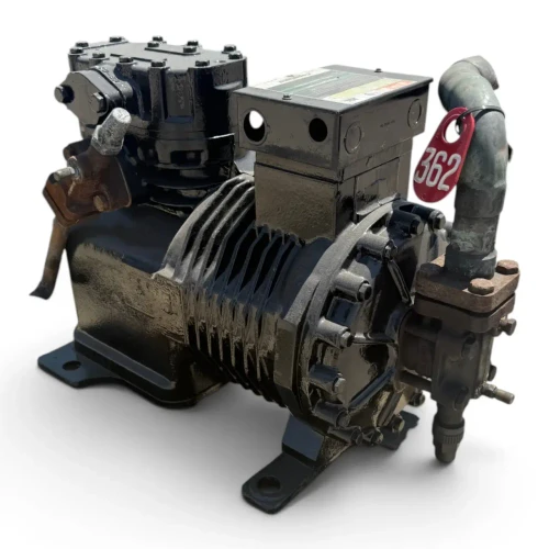 Three-quarter front-right view of a used Copeland 9RS2-076A-TFC 7.5 HP compressor, 3 phase 208-230 volt, showing its black housing with cooling fins, silver Emerson Copeland nameplate, a foil-wrapped copper line at the top left, and a yellow tag hanging near the base.