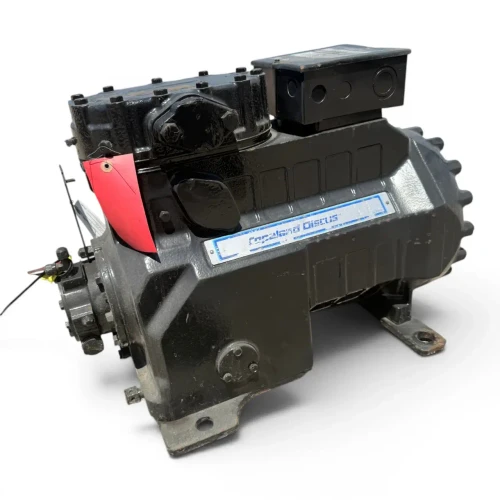 Front-angled view of the used Copeland 3DB3-R12ME-TFC 10 HP compressor, 3 phase 208-230 volt, showing a corroded green-tinged copper fitting at the top, the terminal box, and the red inventory tag near the valve assembly.