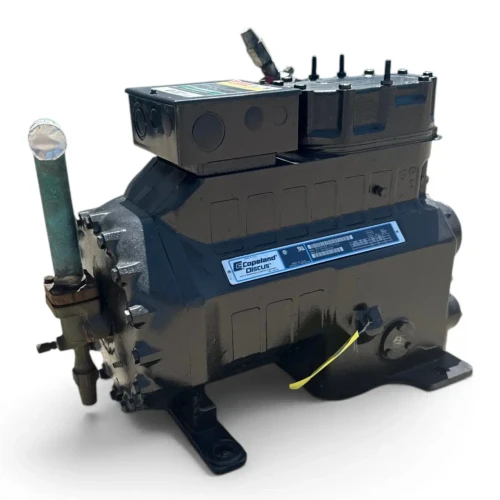 Front-angled view of the used Copeland 3DS3A-100L-TFD 10 HP compressor, 3 phase 460 volt, showing the rating plate, a yellow service tag, and the corroded copper hose from a slightly different angle and lighting.