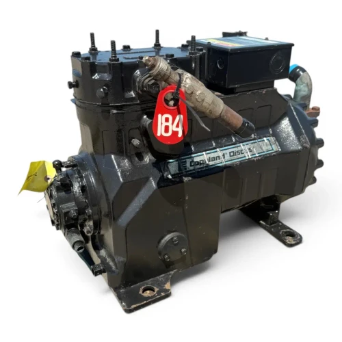 Closer front-left three-quarter view of the used Copeland 3DS3-R17ME-TFC 15 HP compressor, showing the red "184" tag more prominently against the "Copeland Discus" nameplate and a rust-toned copper elbow fitting extending from the valve body.