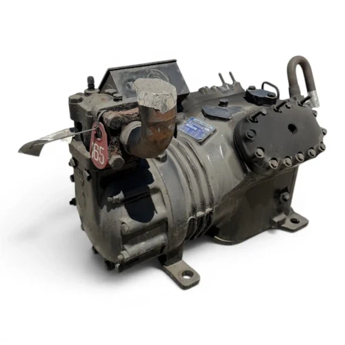 Front-on view of the used Copeland 4RL1-150A-TSK 15 HP compressor with a gray "Copeland Quality" warning panel mounted on the terminal box, a yellow "ADD OIL TO COMPRESSOR" tag hanging at left, and a foil-wrapped copper tube arcing over the top.