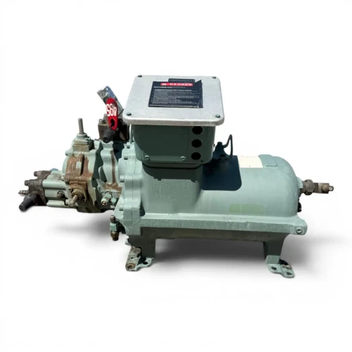 Side profile view of the used Carlyle 06TRC033F2EA 15 HP compressor (3 phase 460 volt) showing the full length of the mint-green shell, the Carlyle nameplate, a rust-streaked coupling flange at the left end, and a foil-capped fitting at the far right.