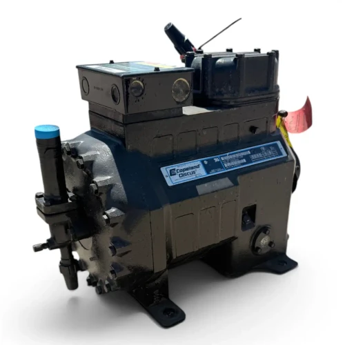 Front-left view of the used Copeland 2DC3-050E-TFC 5 HP Discus compressor (3 phase, 208-230 volt) from a slightly different angle, showing the blue-capped valve at left, the nameplate, and the red inventory tag on the right side.