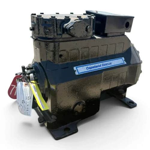 Front view of a used Copeland 3DA3-F28KE-TFC 6 HP compressor (3 phase 208-230 volt), a black cast housing with the "Copeland Discus" nameplate, a black terminal box on the right, and a red inspection tag with a yellow inventory tag hanging from the crankcase.