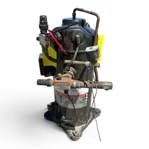 Front-right view of a used Copeland ZBD45KCE-TF5 6 HP scroll compressor (3 phase 208-230 volt), a black cylindrical shell with a yellow "add oil to compressor" tag hanging from the top and foil-wrapped copper fittings on the left.