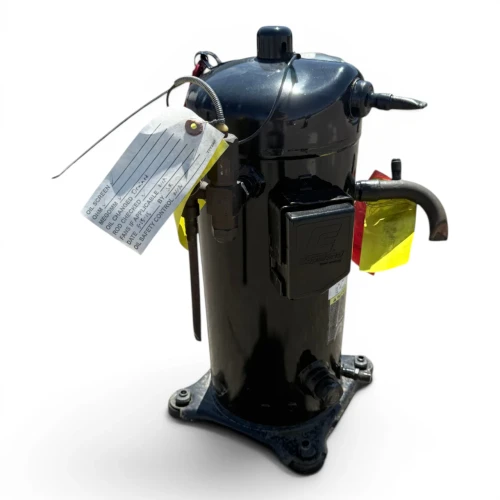 Front-left view of a used Copeland ZF18K4E-TF5 6 HP scroll compressor (3 phase 208-230 volt), a dusty black cylindrical shell with a red round tag and a red/yellow paper tag on the service valve.