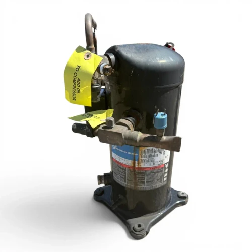 Front-left view of a used Copeland ZF18KVE-TFD 6 HP scroll compressor (3 phase 460 volt), showing the "ZF18KVE-TFD" model label, a looped copper line at top, and two yellow "ADD OIL TO COMPRESSOR" tags overlapping.