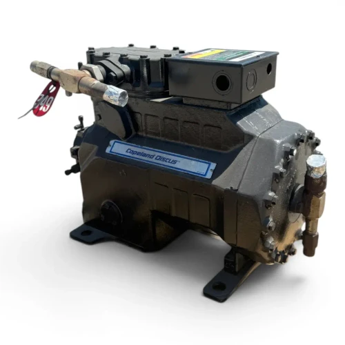 Three-quarter front-right view of the used Copeland 3DA3-R10ME-TFD 7.5 HP compressor, 3 phase 460 volt, showing a red round inventory tag and a yellow oil-reminder tag hanging together near the top valve.