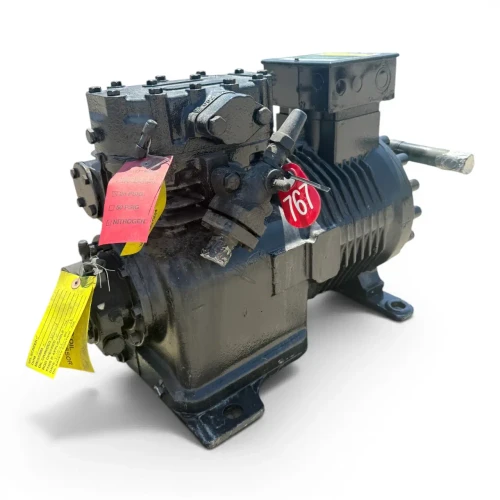 Close three-quarter view of the used Copeland 9RC1-101A-TFD 10 HP compressor highlighting a red round inventory tag numbered "767" and a yellow pressure-test checklist tag with "NITROGEN" checked, hanging from the service valve.