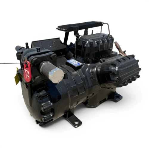 Angled front-right view of the used Copeland 6DL3-F93KE-TSK 27 HP compressor, 3 phase Dual Voltage, showing a red "774" round inventory tag on the top valve, the hex-bolted cylinder head, and a yellow tag hanging below.