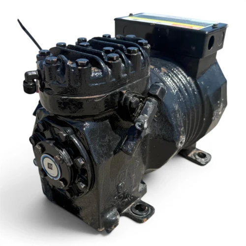 Front-angled view of the used Copeland KAKA-010A-TAC 1 HP compressor - 11828, showing the rating plate reading "Copeland Copelametic KAKA-010A-TAC-800," a pink/red service tag with handwritten notes hanging from the valve fitting, and a cable tie on the dome.