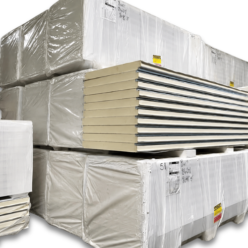 Stacked pallets of insulated cold storage panels wrapped in plastic, showing construction