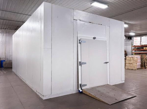 White used walk-in commercial freezer with closed hinged door and ramp