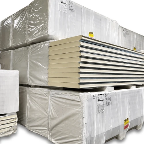 Stacked pallets of insulated cold storage panels wrapped in plastic, showing construction