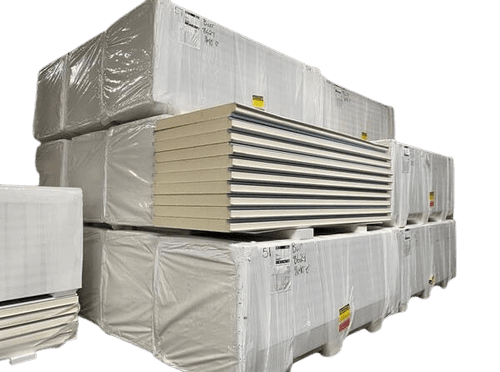 Stacked pallets of insulated cold storage panels wrapped in plastic, showing construction