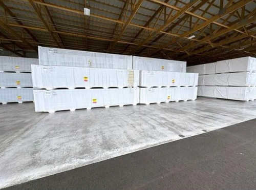 Stacked pallets of insulated cold storage panels wrapped in plastic