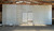 Large, white, used drive-in cooler with doors closed