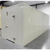 White walk-in cooler unit with closed hinged door, featuring insulated panel walls front left view