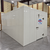 White walk-in cooler unit with closed hinged door, featuring insulated panel walls front left view